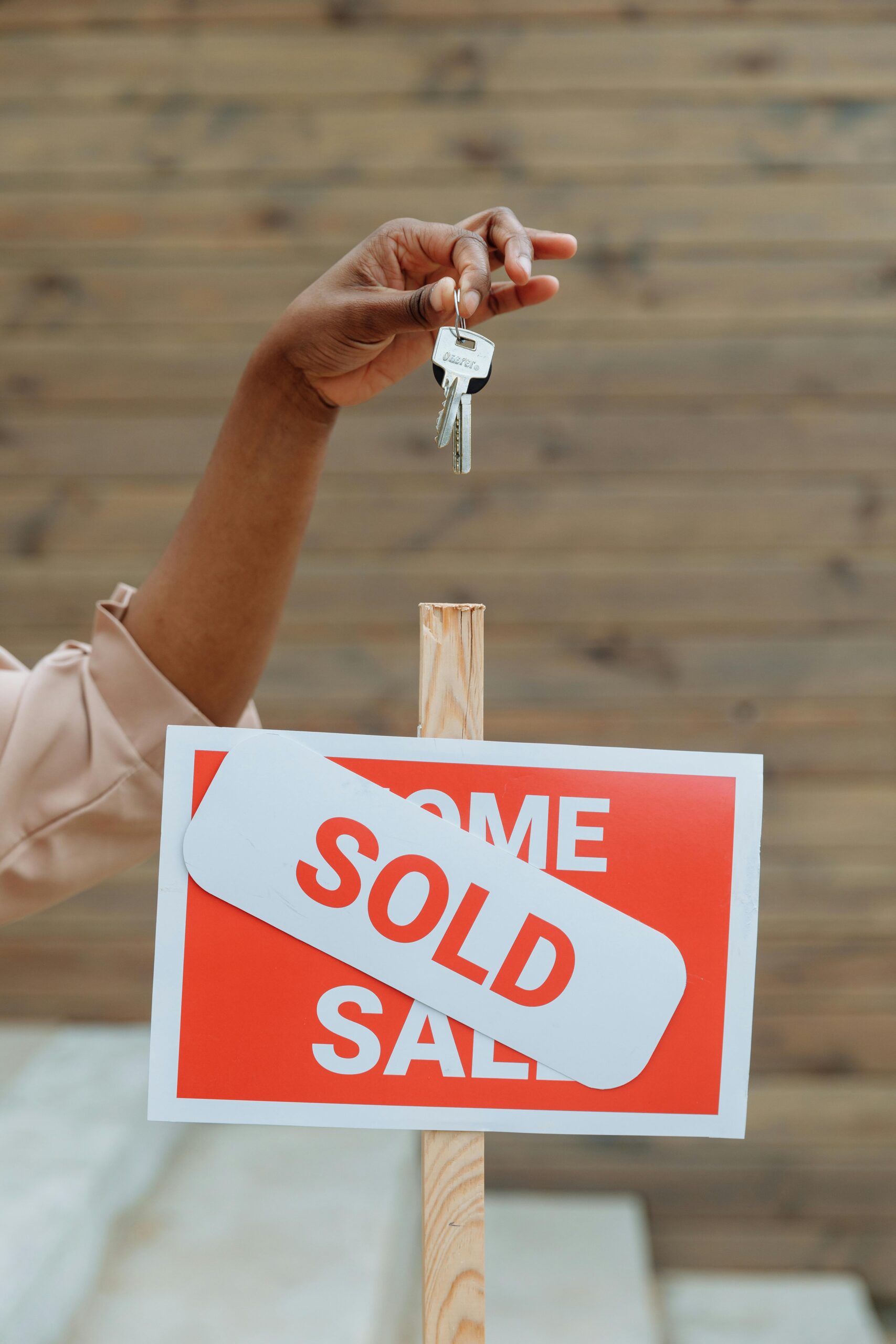 Holding keys over a Sold Sign